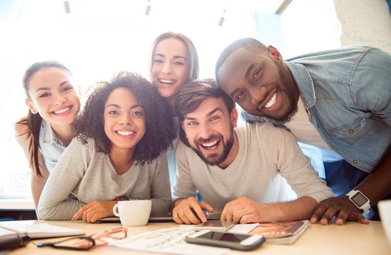 Kuva hymyilevästä tiimistä