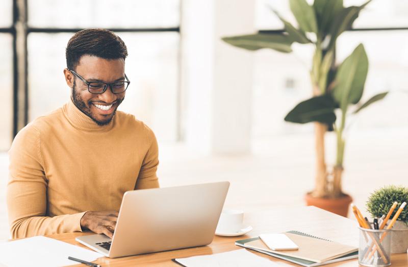 Kuva miehestä kirjoittamassa kannettavaan