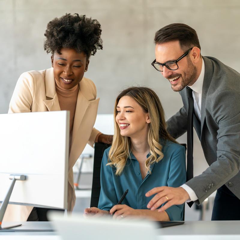 Kuva kolmesta katsomassa hyviä tuloksia näytöltä