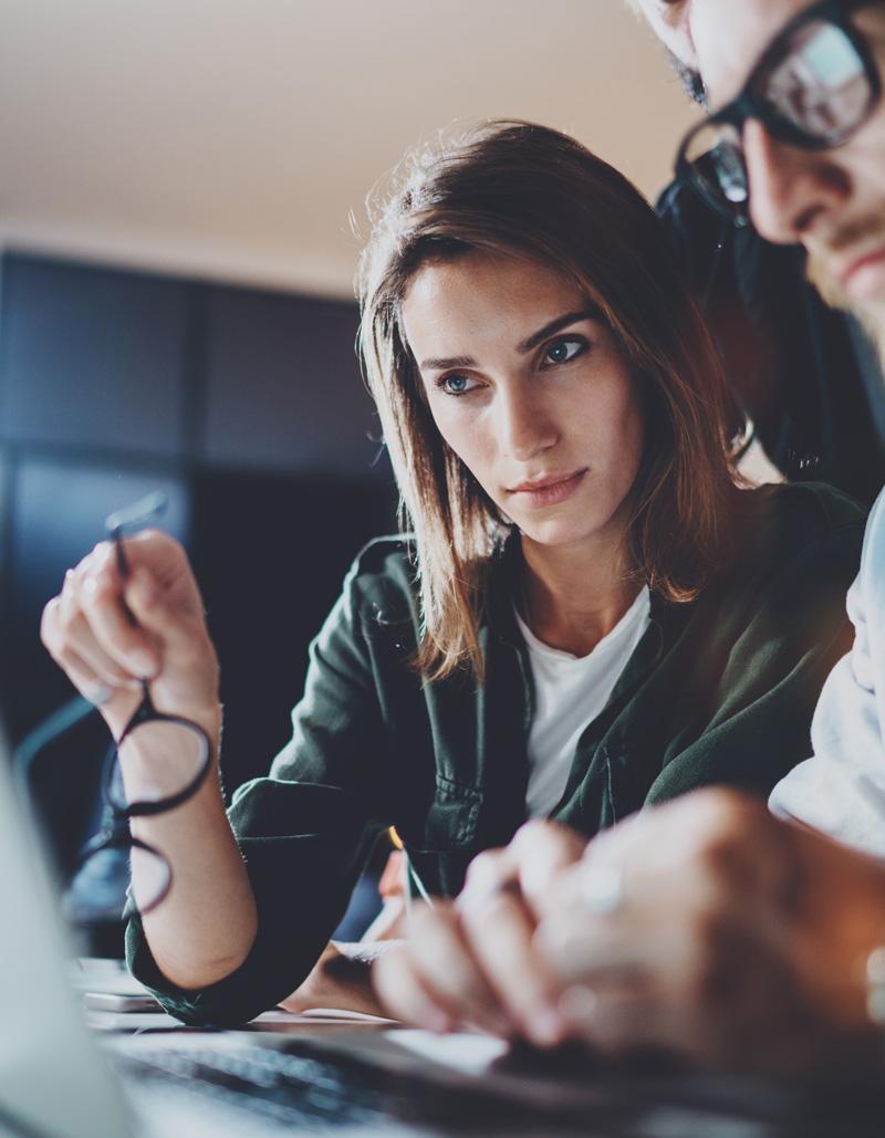 Kuva naisesta ja miehestä tarkasatelemassa tietoja kannettavalla tietokoneella